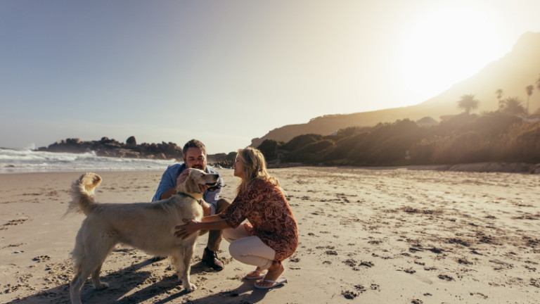 Couple with Golden Retriever dog on the beach