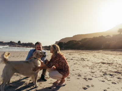 Couple with Golden Retriever dog on the beach